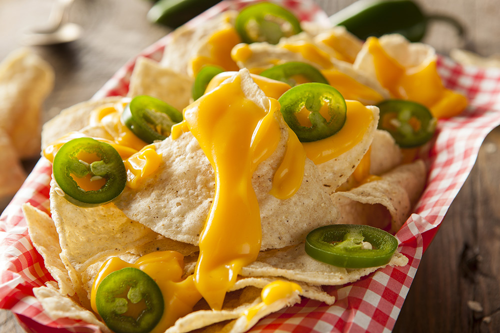 nachos accompagnati da salsa al formaggio e jalapeño