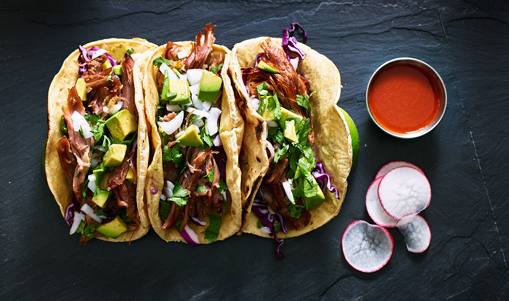 Tacos con carne, avocado e cavolo rosso accompagnati da salsa ketchup