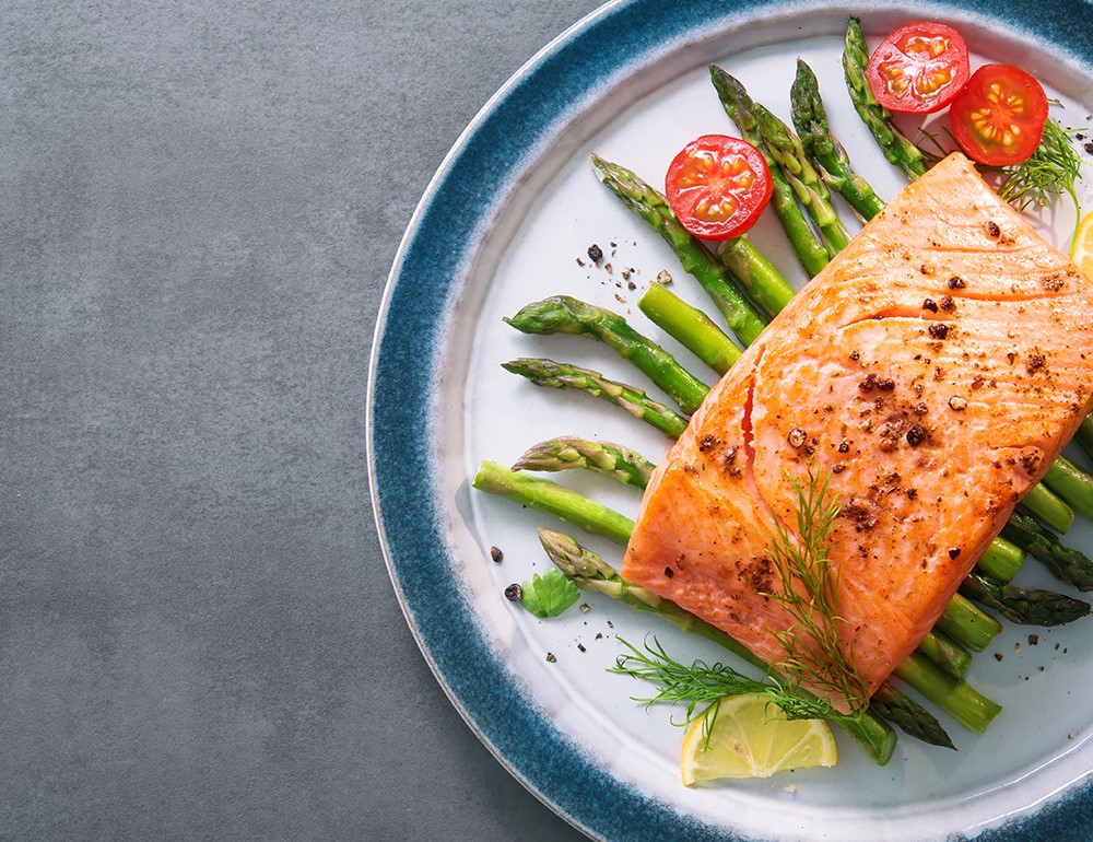piatto di salmone al forno con asparagi e pomodorini