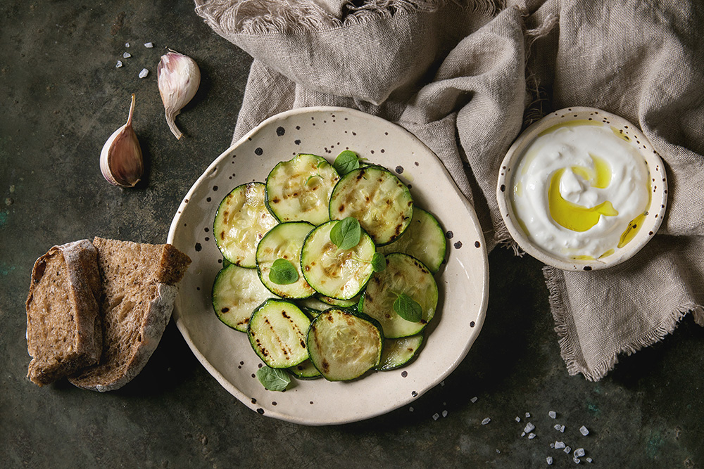 zucchine grigliate con salsa tzatziki, pane ai cereali, olio e basilico