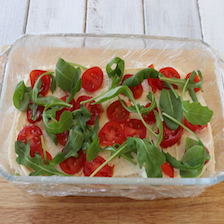 strati di pane, pomodorini e rucola