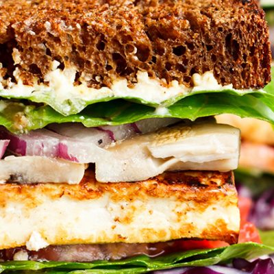 Panino vegetariano con lattuga, cipolla, maionese e tofu impanato