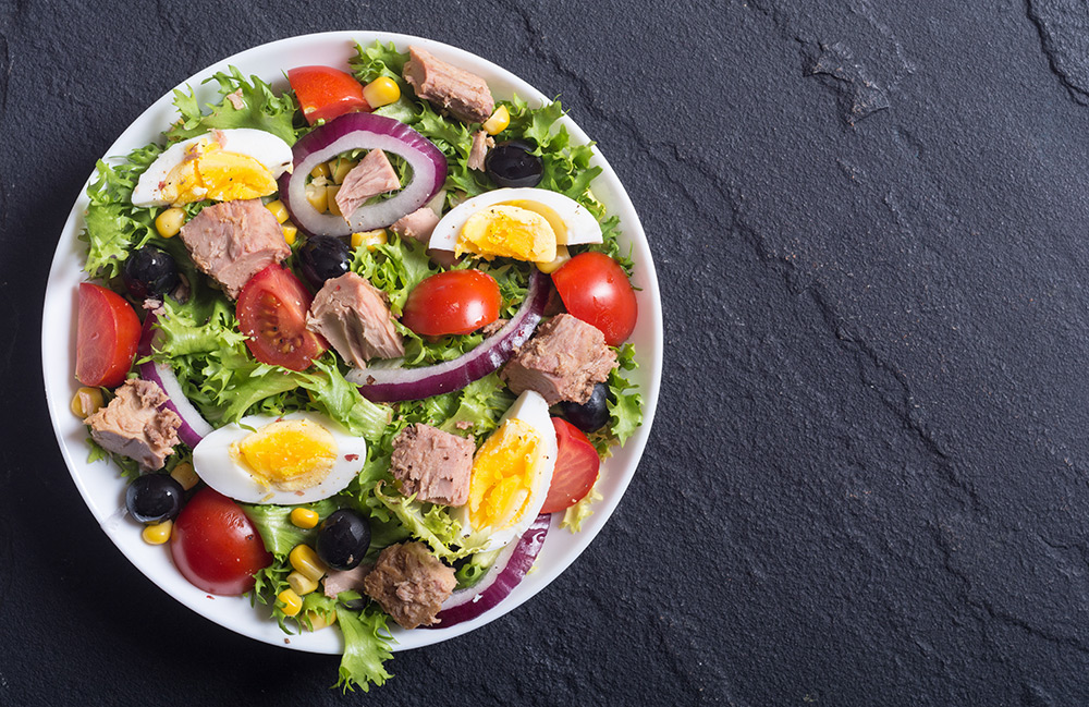 insalata nizzarda con lattuga, tonno, uova, cipolla rossa di tropea, pomodorini